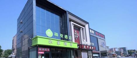 A modern building with a green storefront and a large glass facade.