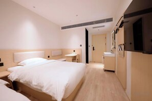 Een hotelkamer met een groot bed, nachtkastjes, een kleine badkamer en een televisie.