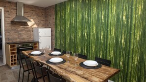 A dining area with a wooden table set for four, a brick wall, and a bamboo wallpaper. - Furnas Sweet Home - Central Zone (Furnas)