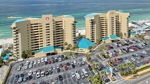 Hotel amb aparcament, vistes a la platja i un edifici gran amb teulada blava.