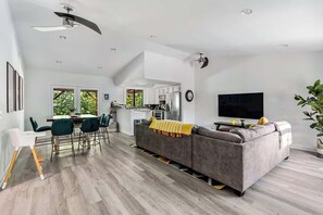 A modern living space with a dining area, kitchen, and seating area.