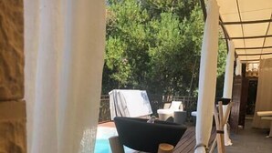 A wooden deck with a pool, outdoor seating, and a covered area with columns. - L'ESTAOU DE FINOU*** (Saint-Paul-et-Valmalle)