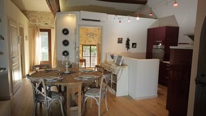 Une cuisine spacieuse avec une table à manger en bois, des armoires blanches et un îlot central intégré.