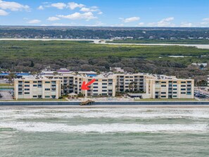 A multi-story hotel with a swimming pool and a view of the surrounding landscape.