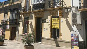 Un immeuble à la façade jaune, doté de balcons décoratifs et d’une enseigne indiquant la possibilité d’achat.