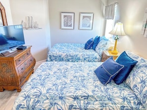 A bedroom with two beds, a dresser, a lamp, and wall art. - South Shore Villas 607 (North Myrtle Beach)