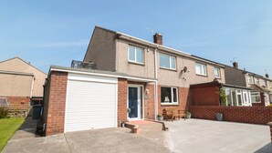 Ein zweistöckiges Wohnhaus mit Garage, Veranda und Ziegelaußenwand.