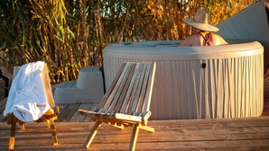 Una terraza de madera con una silla de descanso y un jacuzzi.