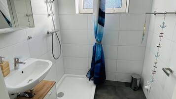 Chuveiro, toalhas de banho, sabonete, papel higiênico