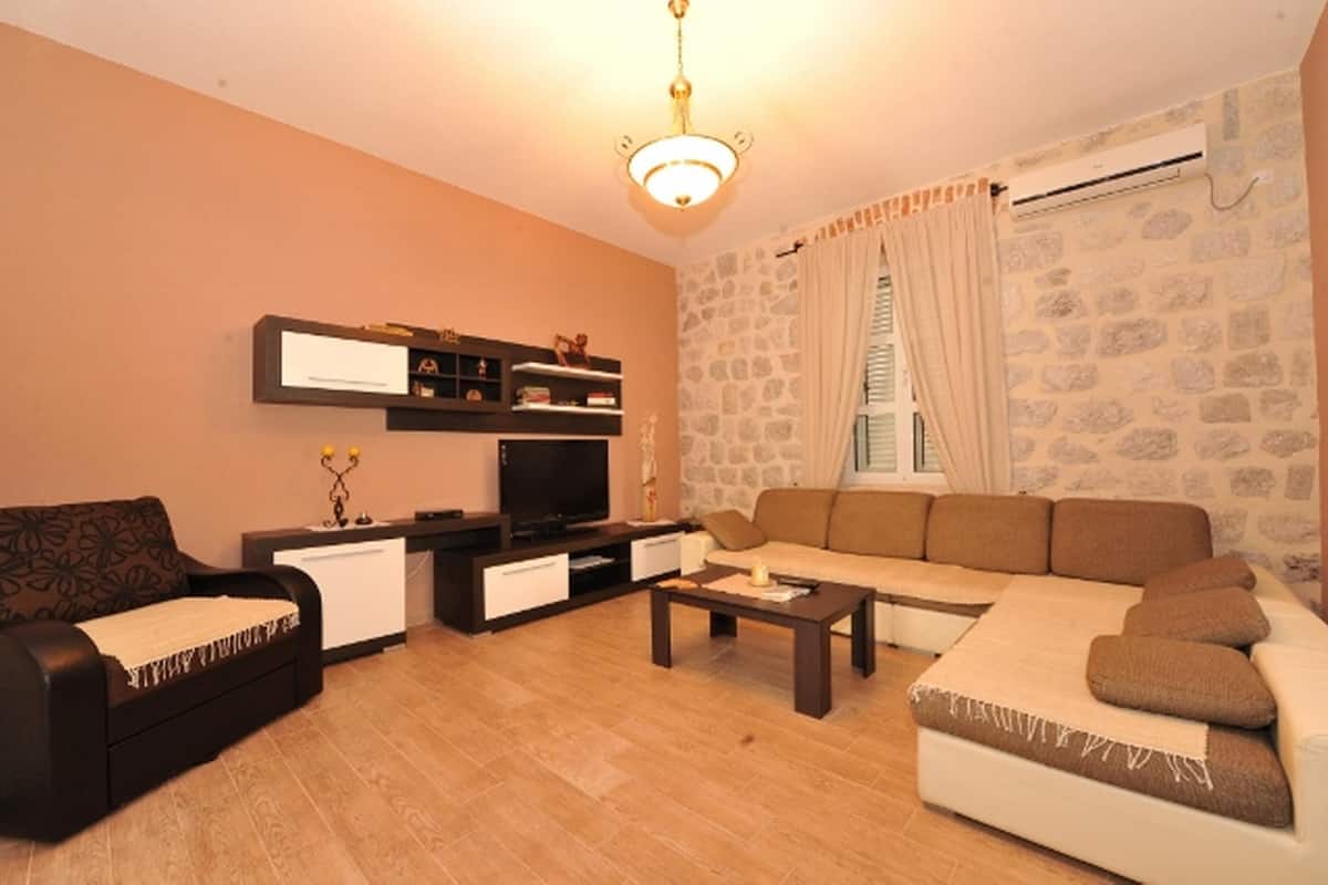 Una sala de estar con un conjunto de sofá, una televisión, una mesa de centro y una chimenea.