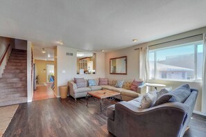 A spacious living room with a sofa set, a coffee table, and a large window providing natural light. - View of Mission Bay plus A/C, pets, and parking (San Diego)