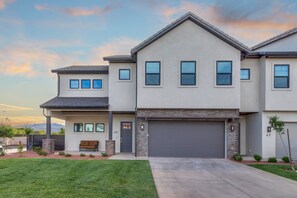 A two-story house with a garage, a front porch, and a well-maintained lawn.
