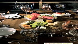 A table set for a meal with various fruits, cheeses, and wine glasses. - Liman Deluxe Hotel (Marmaris)
