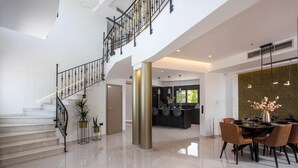 Un interior espacioso con una escalera, un comedor y una cocina.