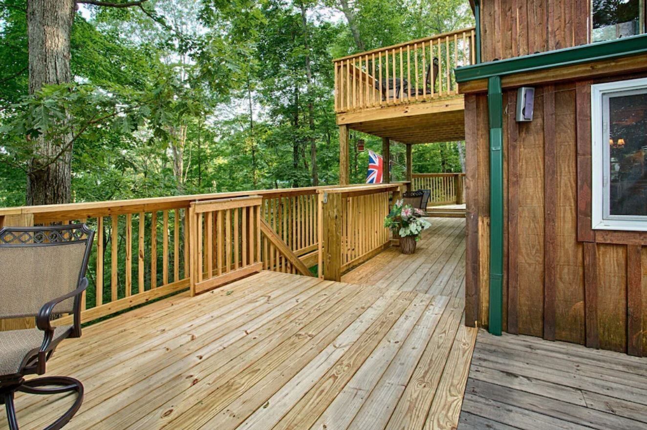 A wooden deck with a chair, a flag, and a small table.