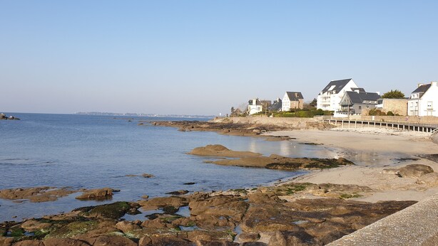 A coastal area with rocky shoreline, white buildings, and a pier extending into the water. - Beautiful, bright apartment at Les Sables Blancs in Concarneau - 150m from the beach and the GR34 (Concarneau)