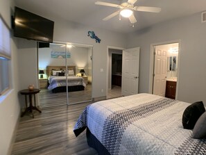 A bedroom with a bed, a ceiling fan, a TV, and a door leading to another room. - Blackjack Bluff by Mesquite Vacation Rentals with City View and $510 in free daily activities (Mesquite)