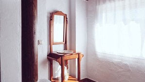 A room with a wooden chair, a wooden table, and a mirror. - Casa Lola - Casa N2 en Zahora (Zahora)