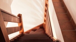 Una escalera con barandillas de madera y peldaños de piedra.