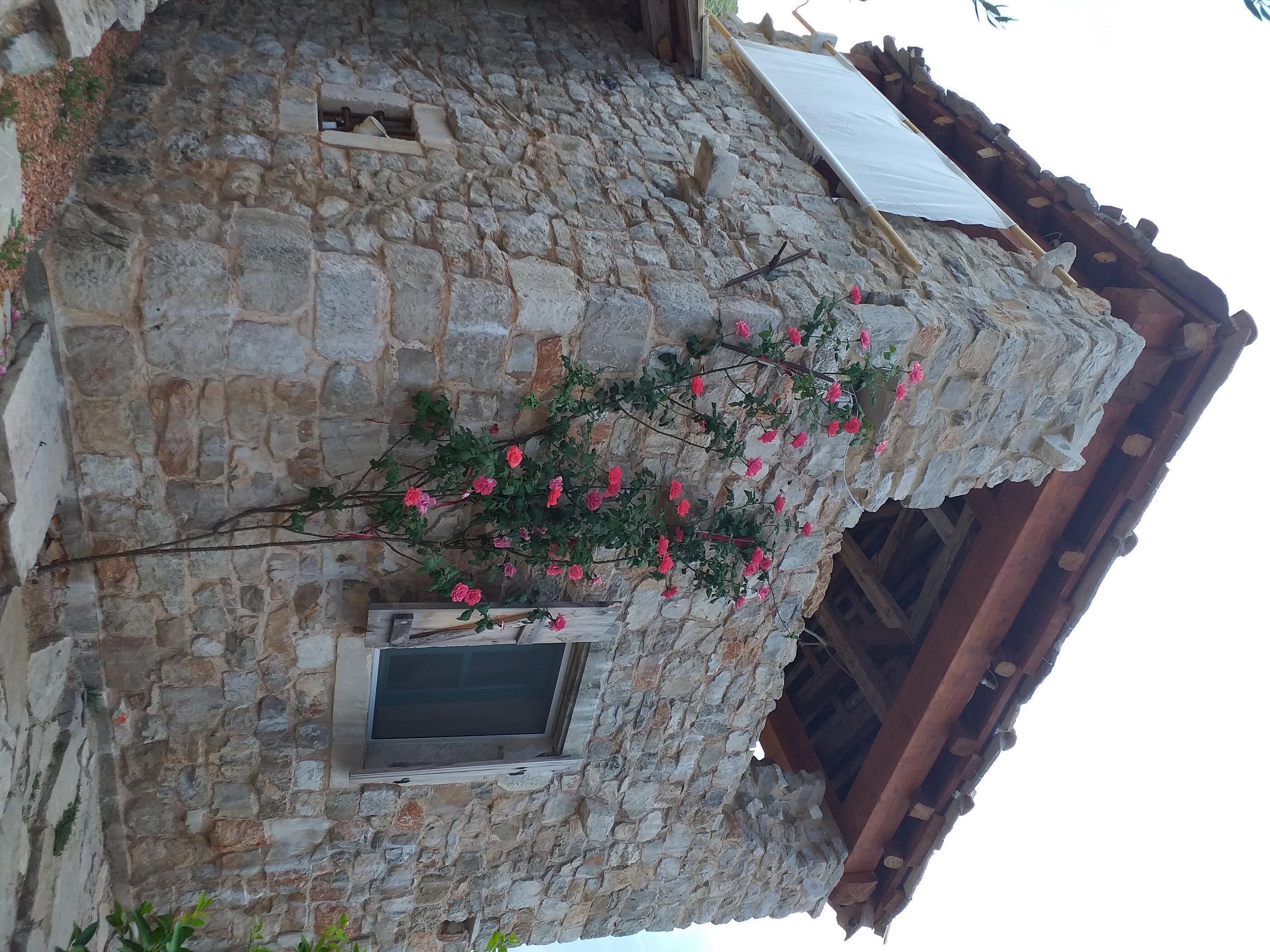 A stone building with a window and a wooden balcony.
