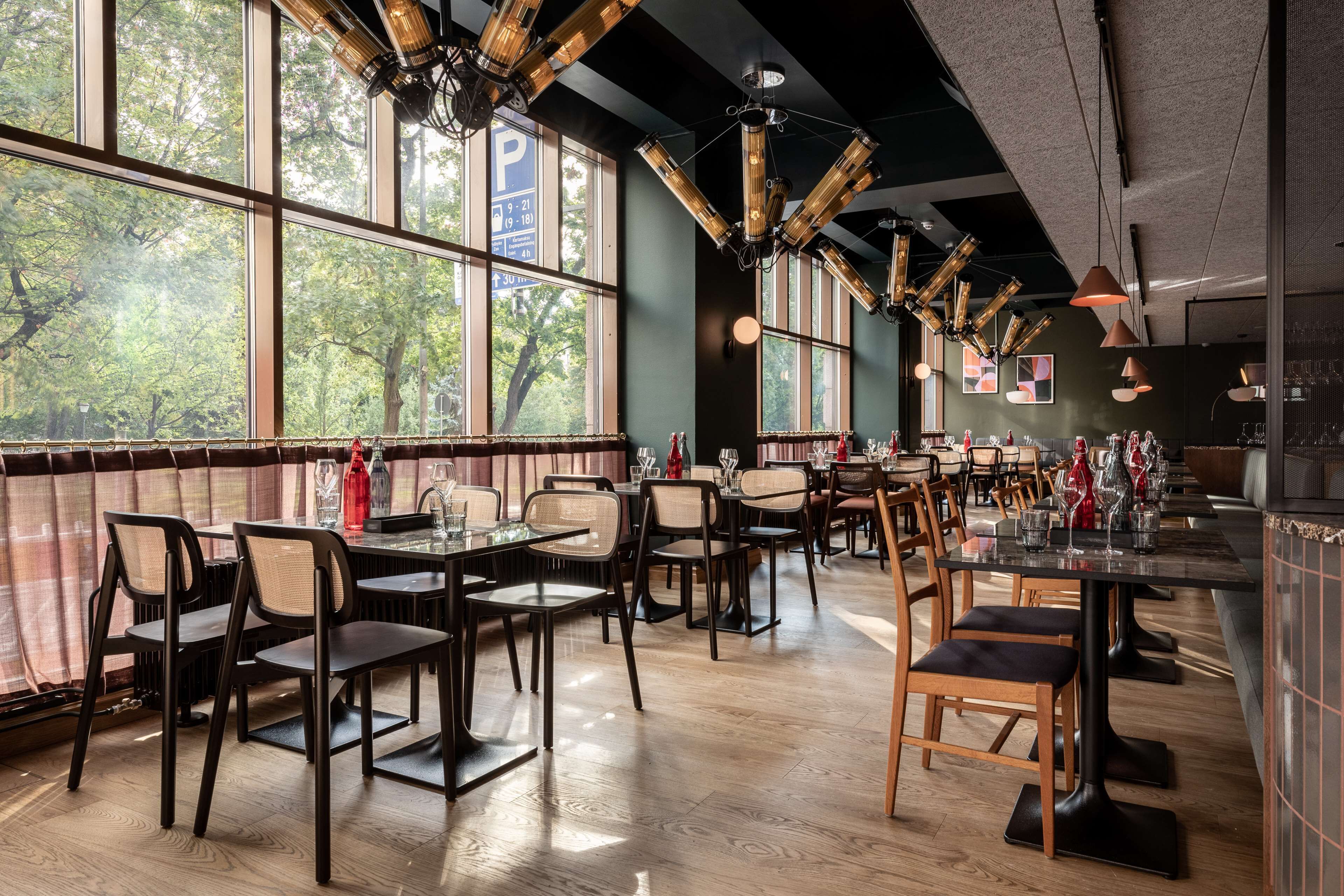 Un restaurante con amplios ventanales, mesas y sillas de madera.