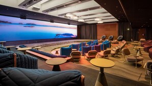Un cine moderno con una pantalla grande, asientos cómodos y un interior bien iluminado.