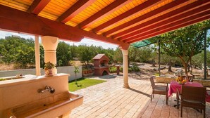 An outdoor patio with a brick barbecue, a stone sink, wicker furniture, and a pergola. - Apartment Irena (Supetar)