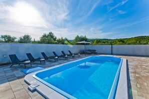 Relax by the pool surrounded by lush greenery and enjoy the serene atmosphere.