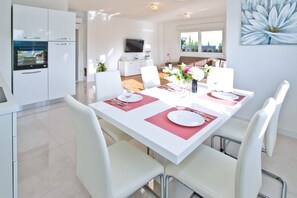 Enjoy meals in this stylish dining area with a long table for four, flat-screen TV, and beautiful floral decor.