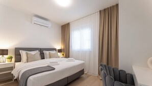Une chambre d’hôtel moderne avec un grand lit, des tables de chevet, un bureau et une chaise.
