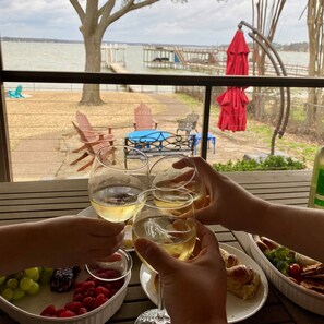 A view from a window overlooking a dock and a grassy area with outdoor furniture. - Sunset View, fully fenced yard, dog friendly (Gun Barrel City)