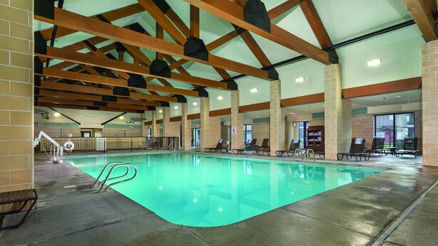 An indoor swimming pool with clear water, surrounded by lounge chairs and a brick wall. - Worldmark Resort,3B2Bath!! Next to park! Sleeps 8 Very NICE (West Yellowstone)