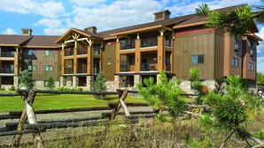A multi-story hotel with a central courtyard, balconies, and a mix of wood and stone exterior. - Worldmark Resort,3B2Bath!! Next to park! Sleeps 8 Very NICE (West Yellowstone)