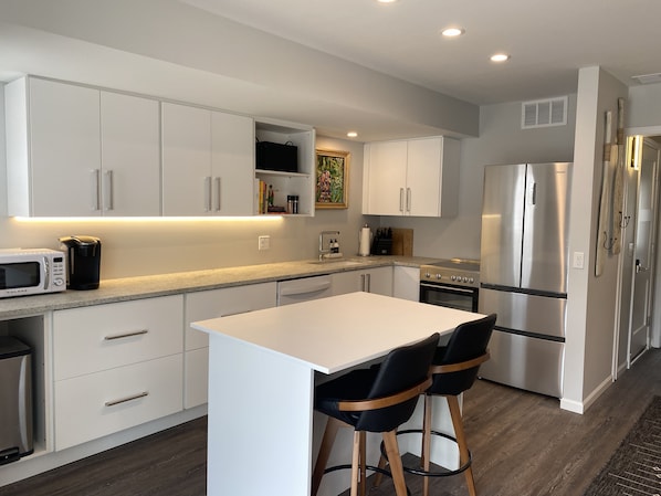 Enjoy cooking in this well-equipped kitchen with a spacious countertop, microwave, coffee maker, and refrigerator.