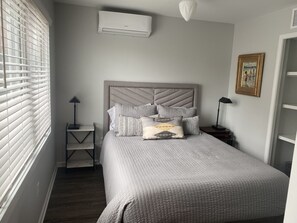 Restful retreat with a large bed, tufted headboard, and quilted bedspread.