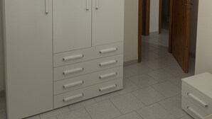 Una habitación con un armario blanco grande, una puerta de madera y una araña.