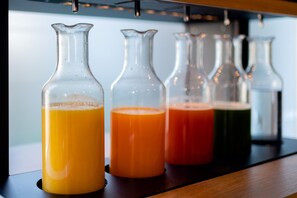 Cuatro botellas de vidrio con líquidos de distintos colores sobre una estantería.
