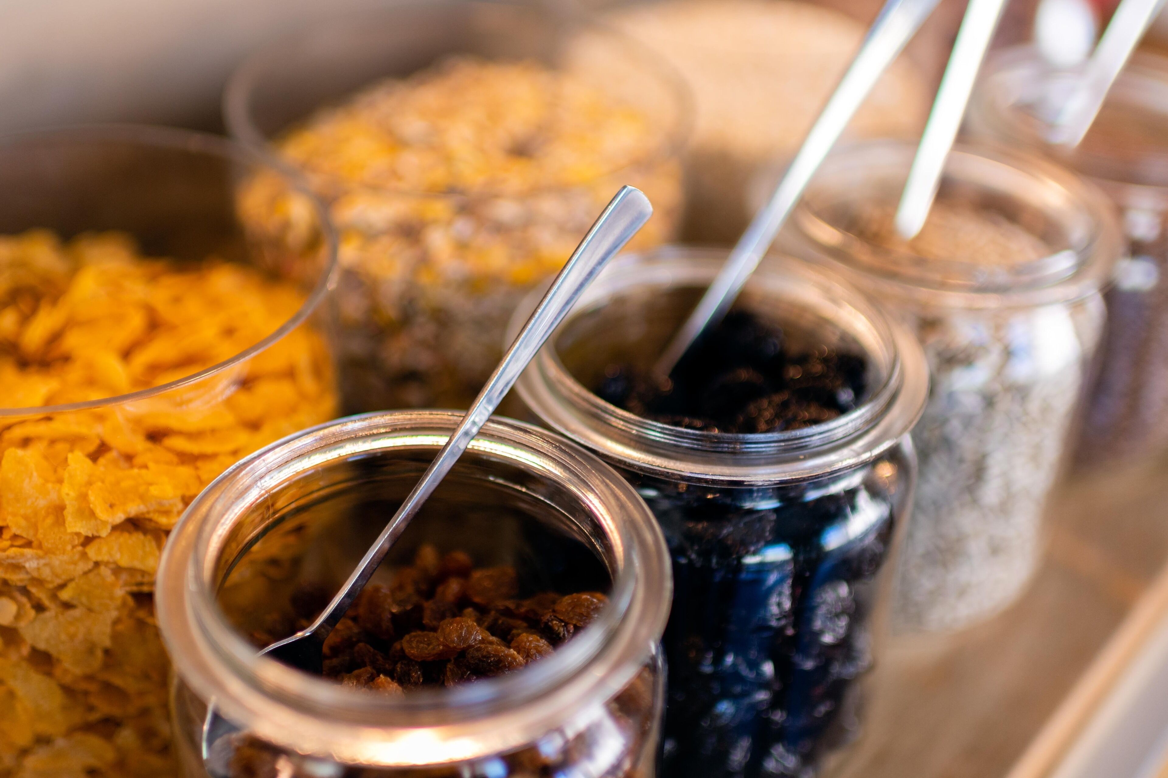 A tray with various food items in jars, including cereal and dried fruits.