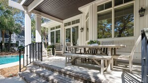 A covered outdoor patio with a pool, steps, and outdoor furniture. - Pristine 2nd row home in Sea Pines w/ great outdoor space, private pool & spa (Hilton Head Island)