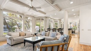 A spacious living room with a high ceiling, large windows, and a view of the outdoors. - Pristine 2nd row home in Sea Pines w/ great outdoor space, private pool & spa (Hilton Head Island)