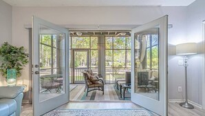 A room with a large sliding glass door leading to an outdoor patio with a dining table and chairs.
