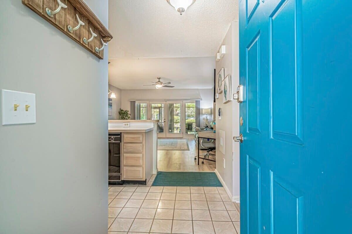 Una cocina con puerta azul, ventilador de techo y vista al área de comedor.