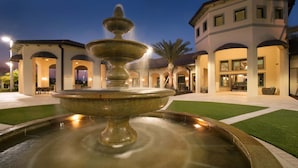 A fountain in a courtyard with a building in the background. - Last Minute Disney Getaway! Luxury Condo with Private Balcony. Book Now! #56633 (Orlando)