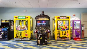 A gaming arcade with claw machines and a central arcade machine. - Last Minute Disney! Private Pool, Hot Tub, Game Room & Themed Bedrooms. Book Now! #56567 (Orlando)
