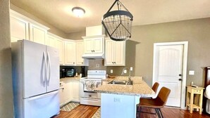 A kitchen with white cabinets, a stainless steel refrigerator, a microwave, an oven, and a sink. - Lovely Guest Apartment<br> (Pace)
