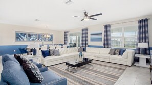 Relax in this stylish living room with a large L-shaped sofa, glass coffee table, and striped area rug.
