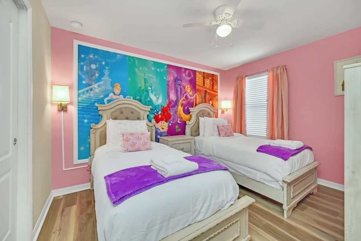 Ein Schlafzimmer mit zwei Betten, einer farbenfrohen Wandmalerei und einem Deckenventilator.