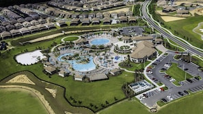 Oversigtsbillede af et feriested med flere swimmingpools, en golfbane og en parkeringsplads.