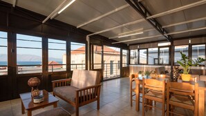 Un balcón amplio con muebles de madera, una mesa y plantas en macetas.