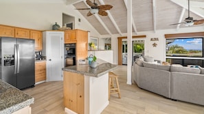 A modern kitchen with a built-in island, wooden cabinets, and a stainless steel refrigerator.